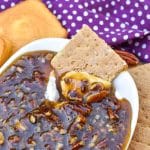 a graham cracker scooping pecan pie dip out of a small white dish