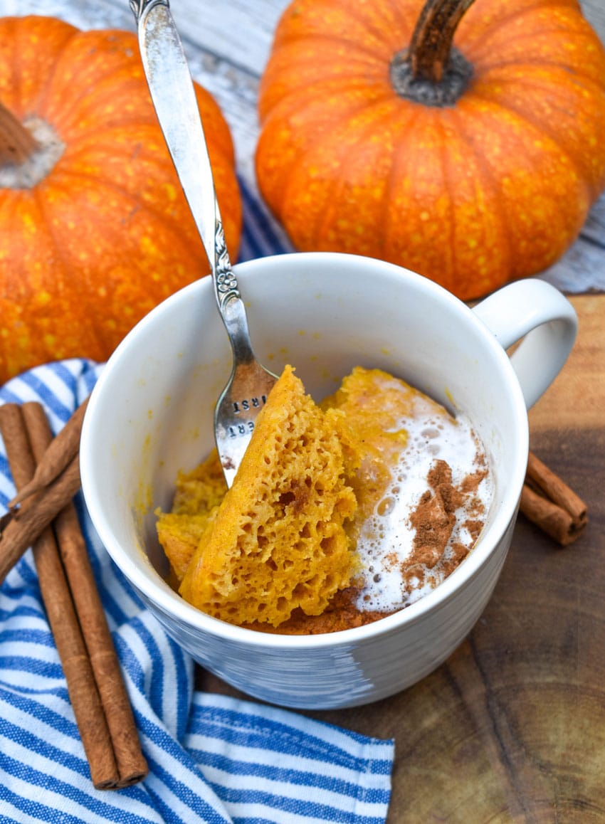 a fork scooping pumpkin cake out of a microwave mug