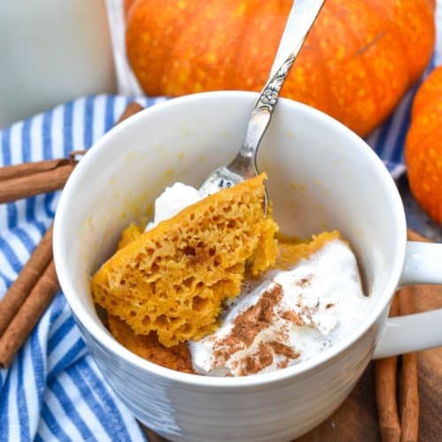 a fork scooping pumpkin cake out of a microwave mug