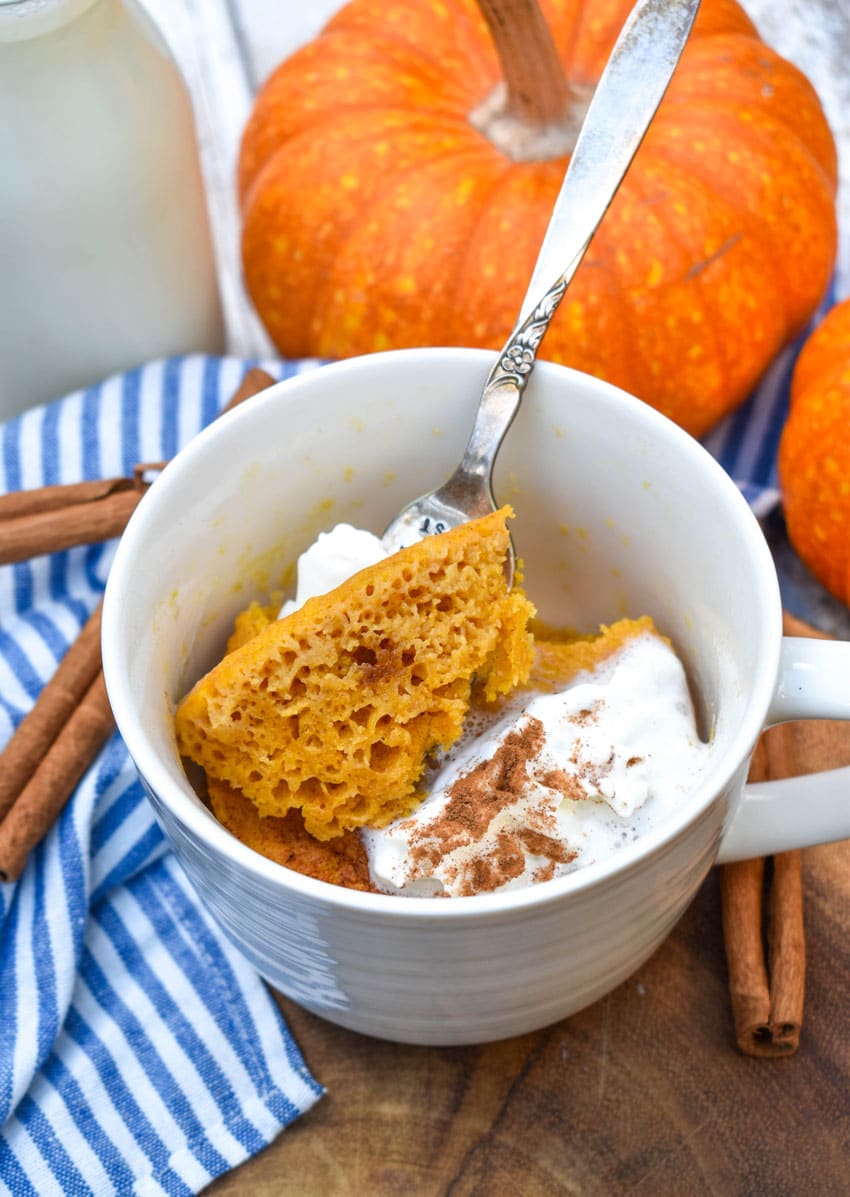 a fork scooping pumpkin cake out of a microwave mug