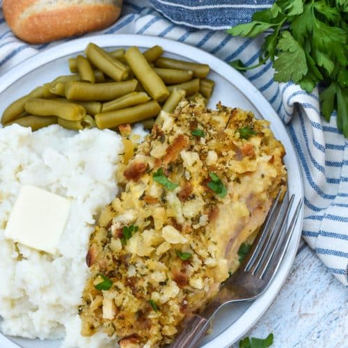 slow cooker chicken cordon bleu next to mashed potatoes and canned green beans on a white plate