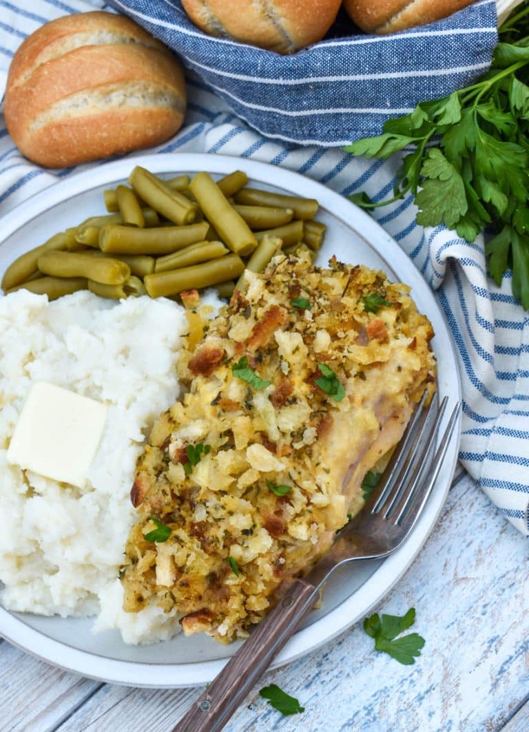 slow cooker chicken cordon bleu next to mashed potatoes and canned green beans on a white plate