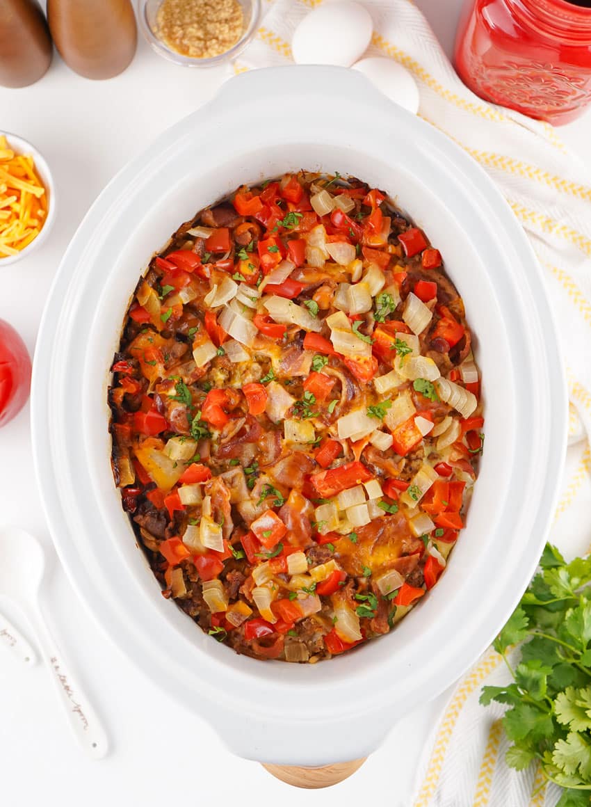 baked breakfast casserole in the white bowl of a slow cooker