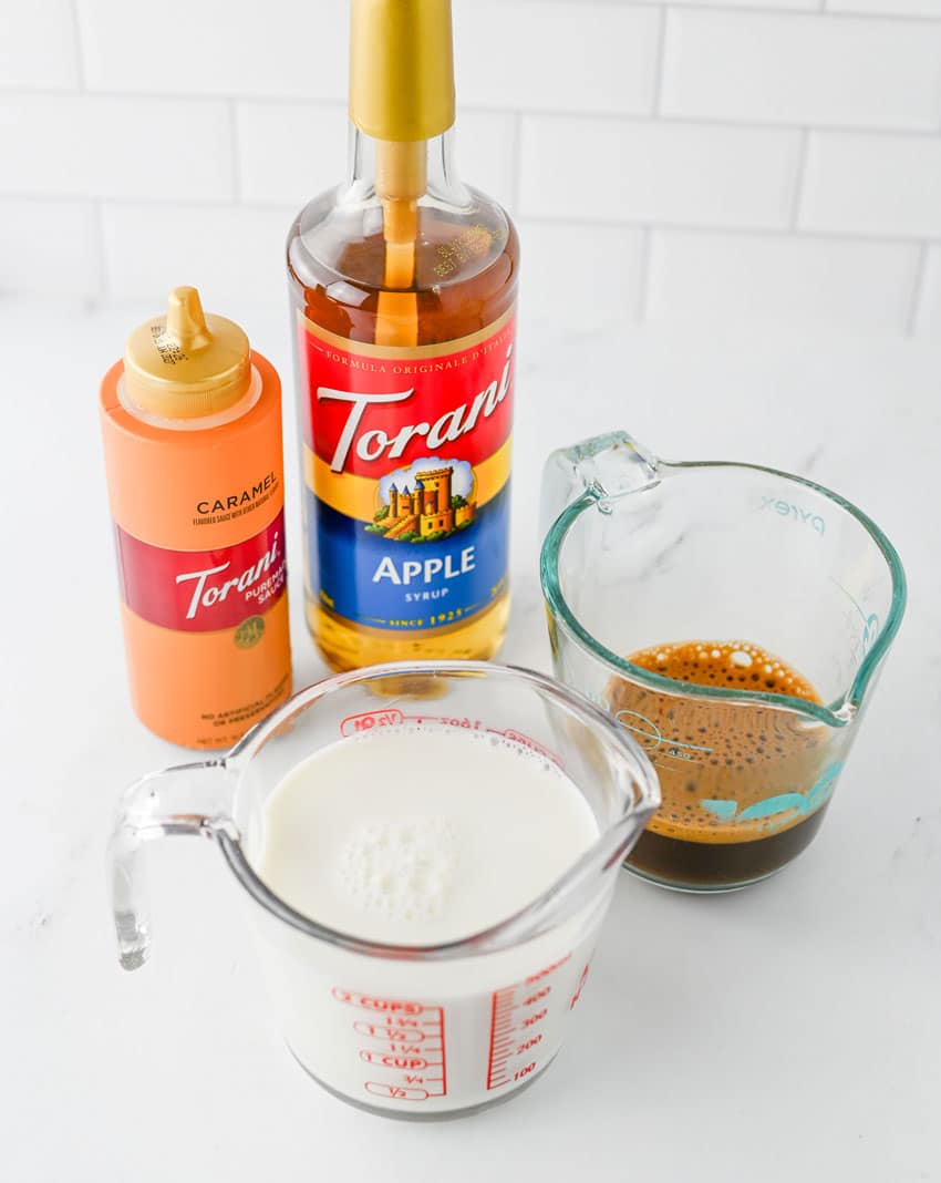 an overhead image showing the measured ingredients needed to make a copycat starbuck's iced caramel apple latte at home