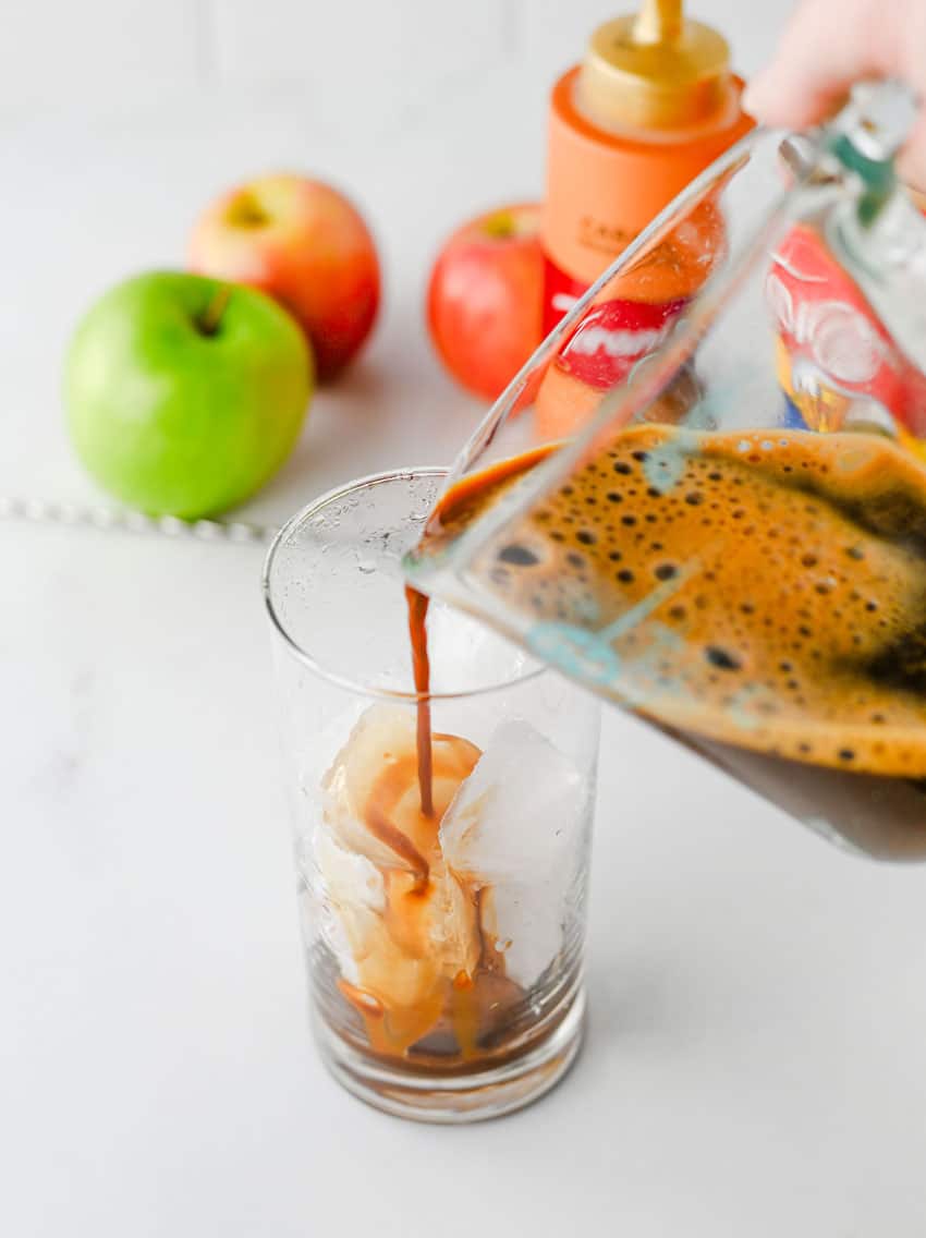 espresso being poured over ice into a small glass jar