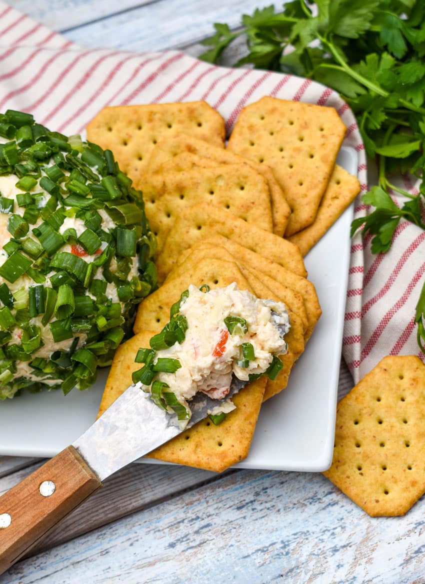 crab rangoon spread on a cracker resting on a white serving platter