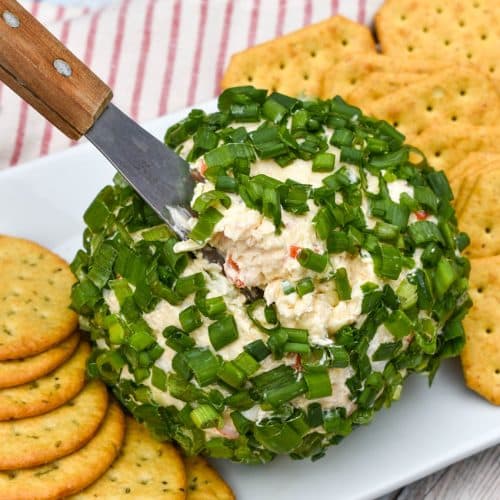 a wood handled cheese serving digging into a crab rangoon cheese ball