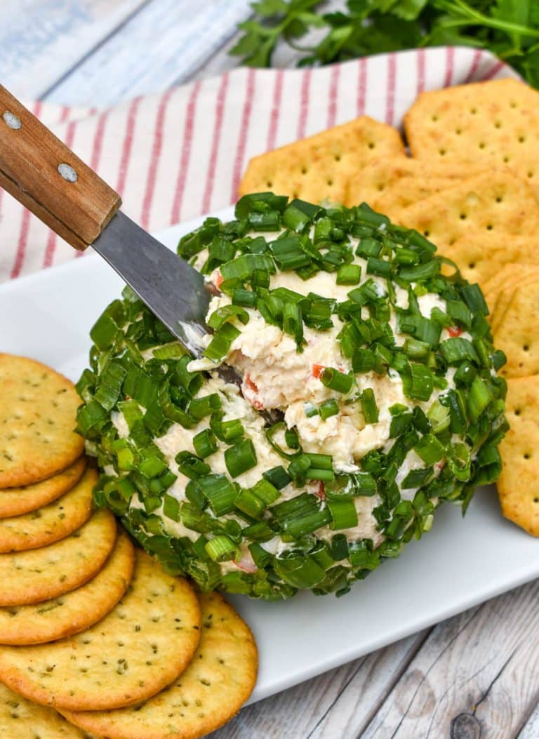 a wood handled cheese serving digging into a crab rangoon cheese ball