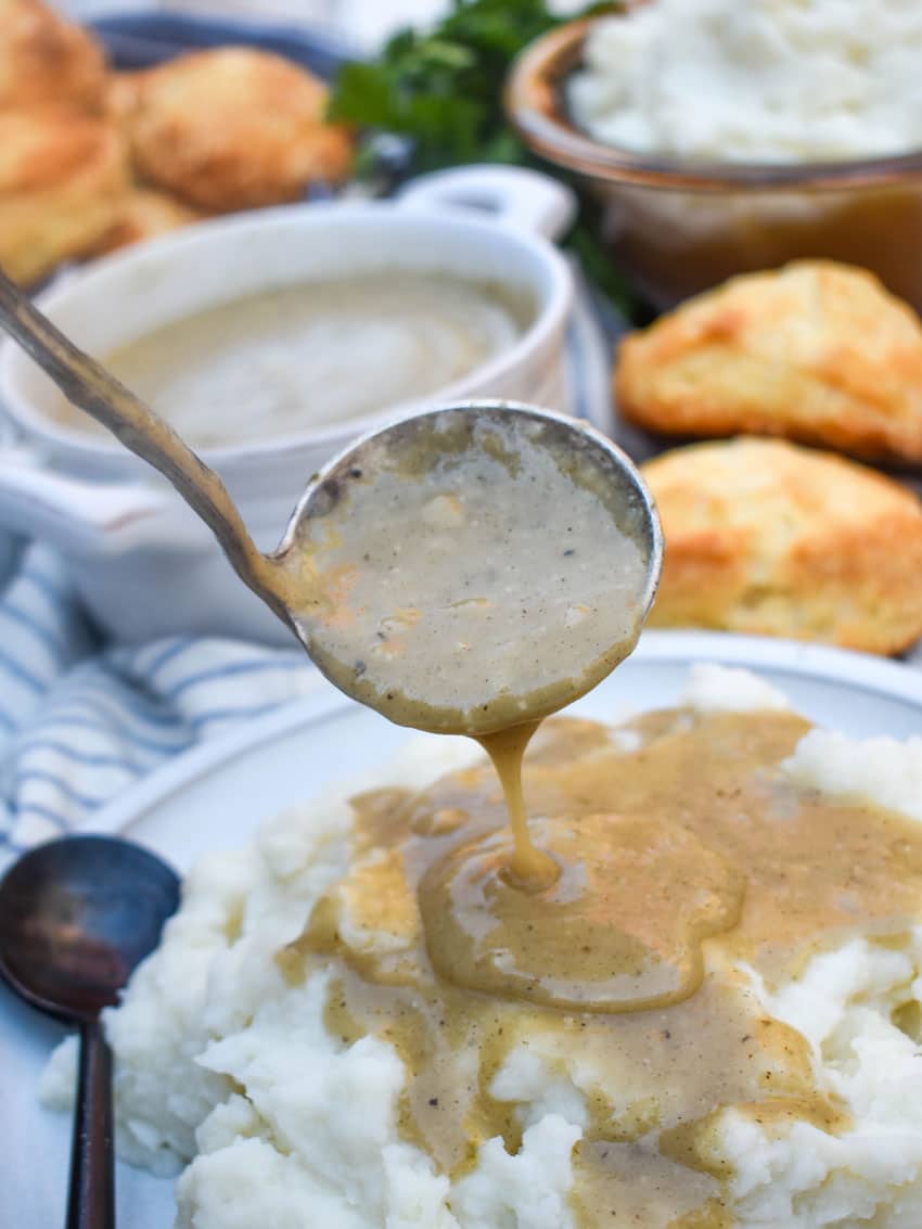 quick and easy chicken gravy being ladled over a plate of mashed potatoes