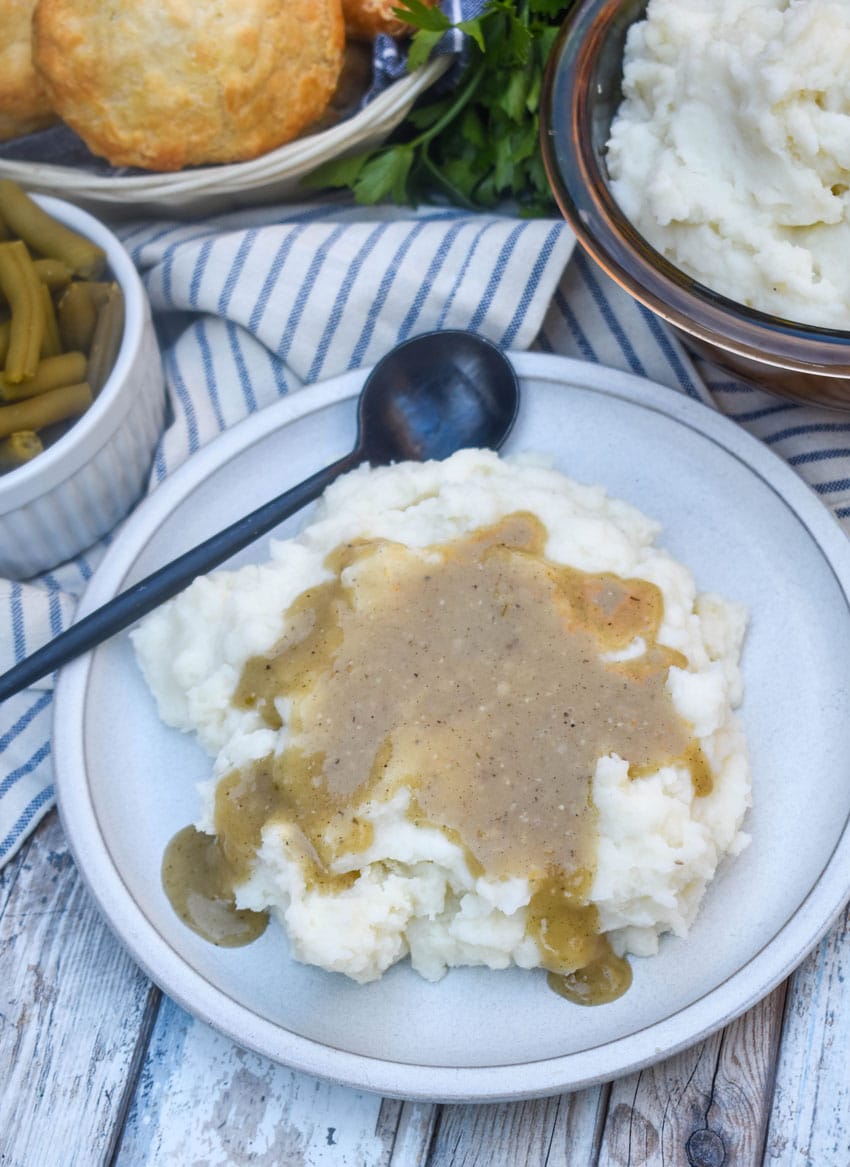 quick and easy chicken gravy over creamy mashed potatoes on a white plate