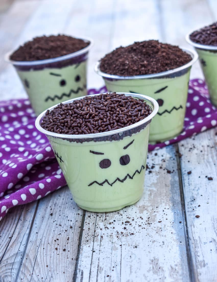 Frankenstein pudding cups on a wooden table