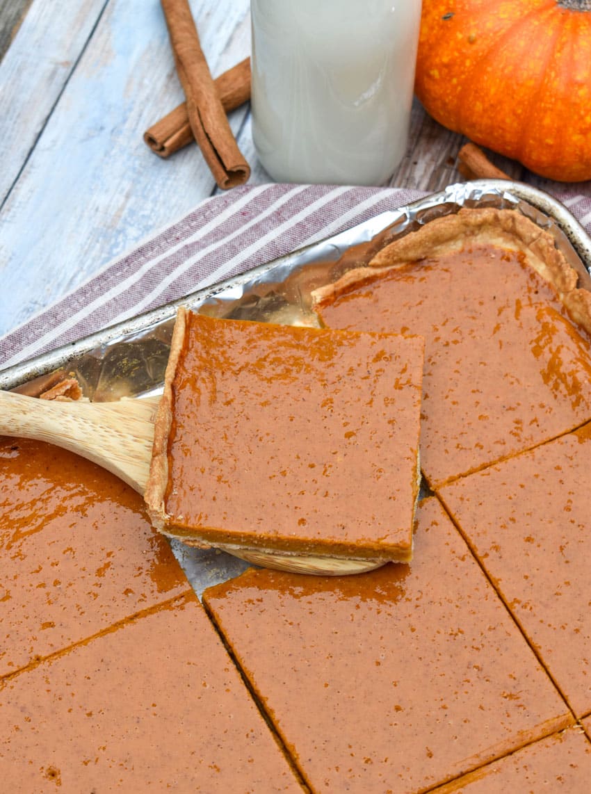 a wooden spatula holding up a slice of pumpkin slab pie