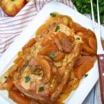 a slow cooked apple pie pork loin on a white serving platter