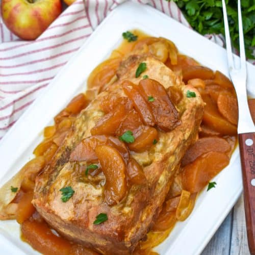 a slow cooked apple pie pork loin on a white serving platter