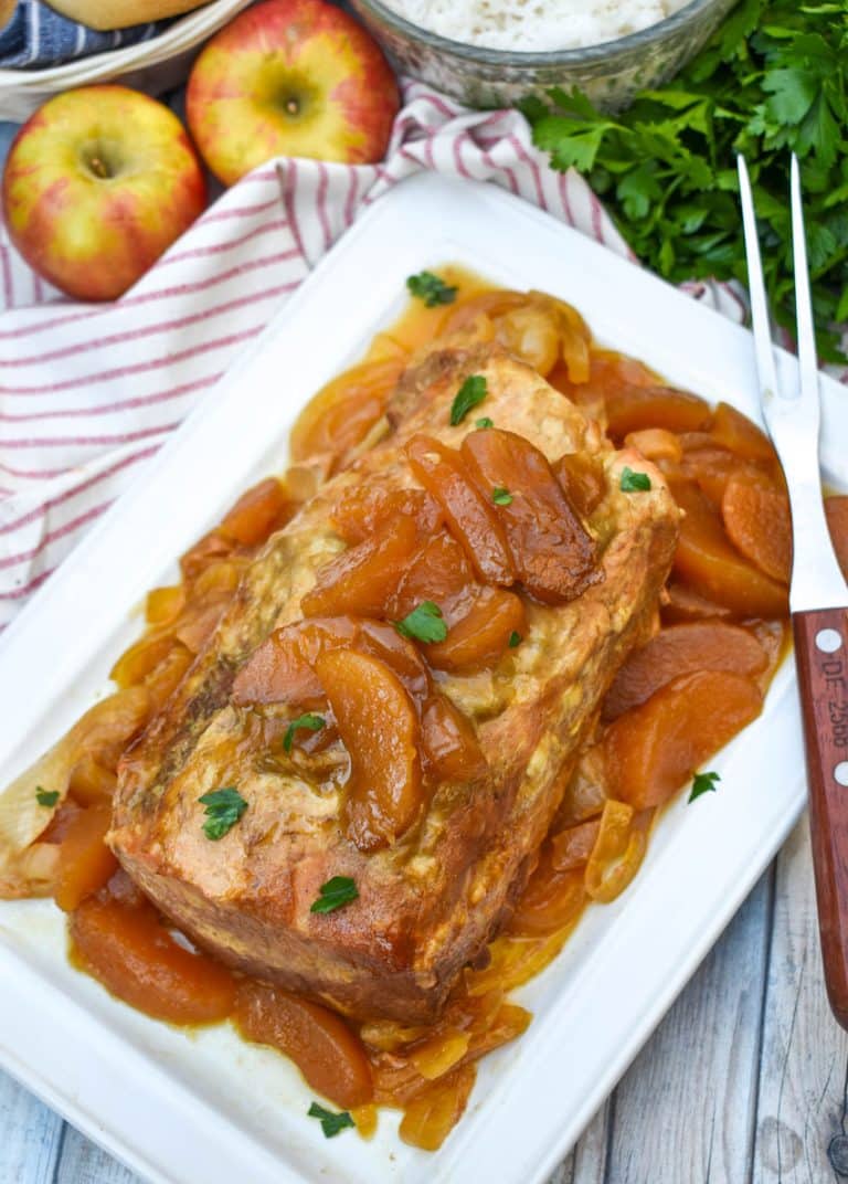 a slow cooked apple pie pork loin on a white serving platter