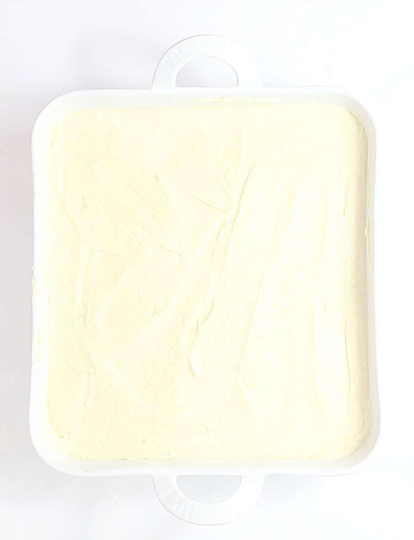 creamy vanilla pudding spread out in an even layer in a white square baking dish