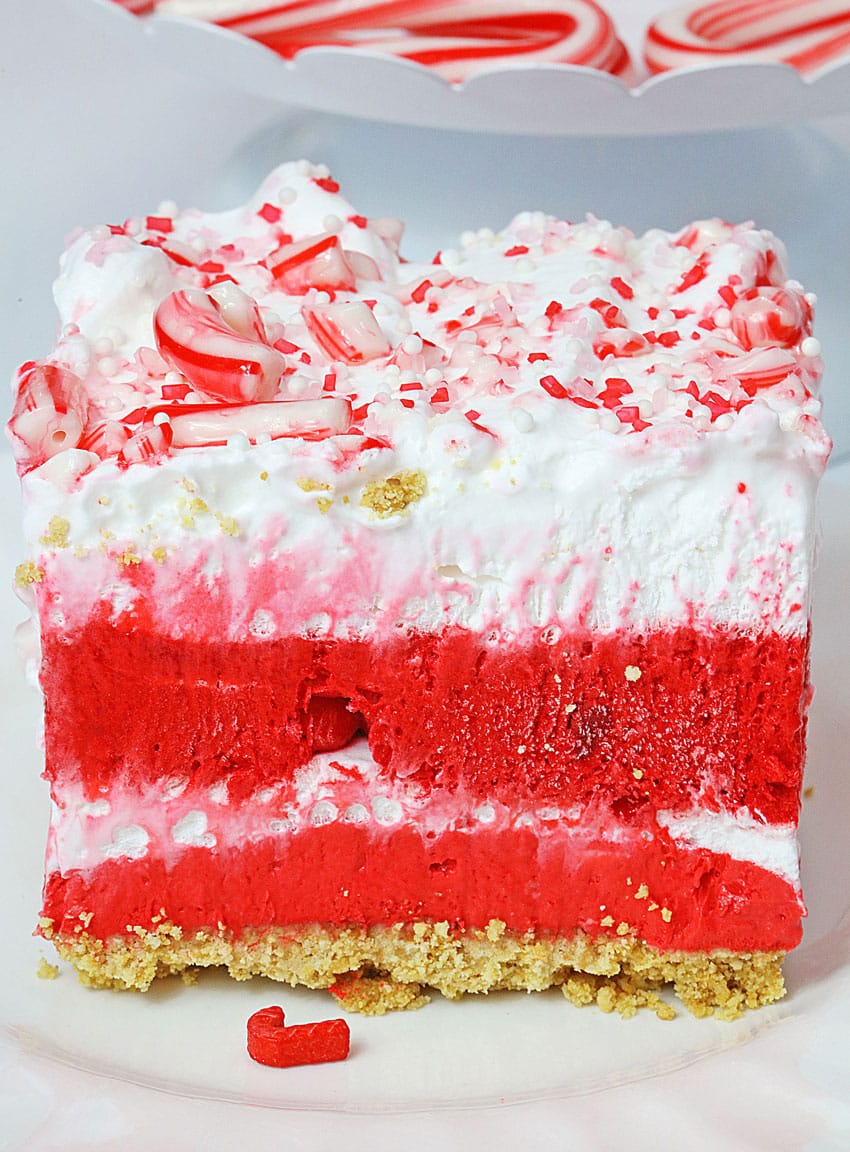 a slice of a candy cane lush dessert on a small white dessert plate