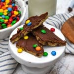 pieces of homemade cookie dough bark on a small white dessert stand