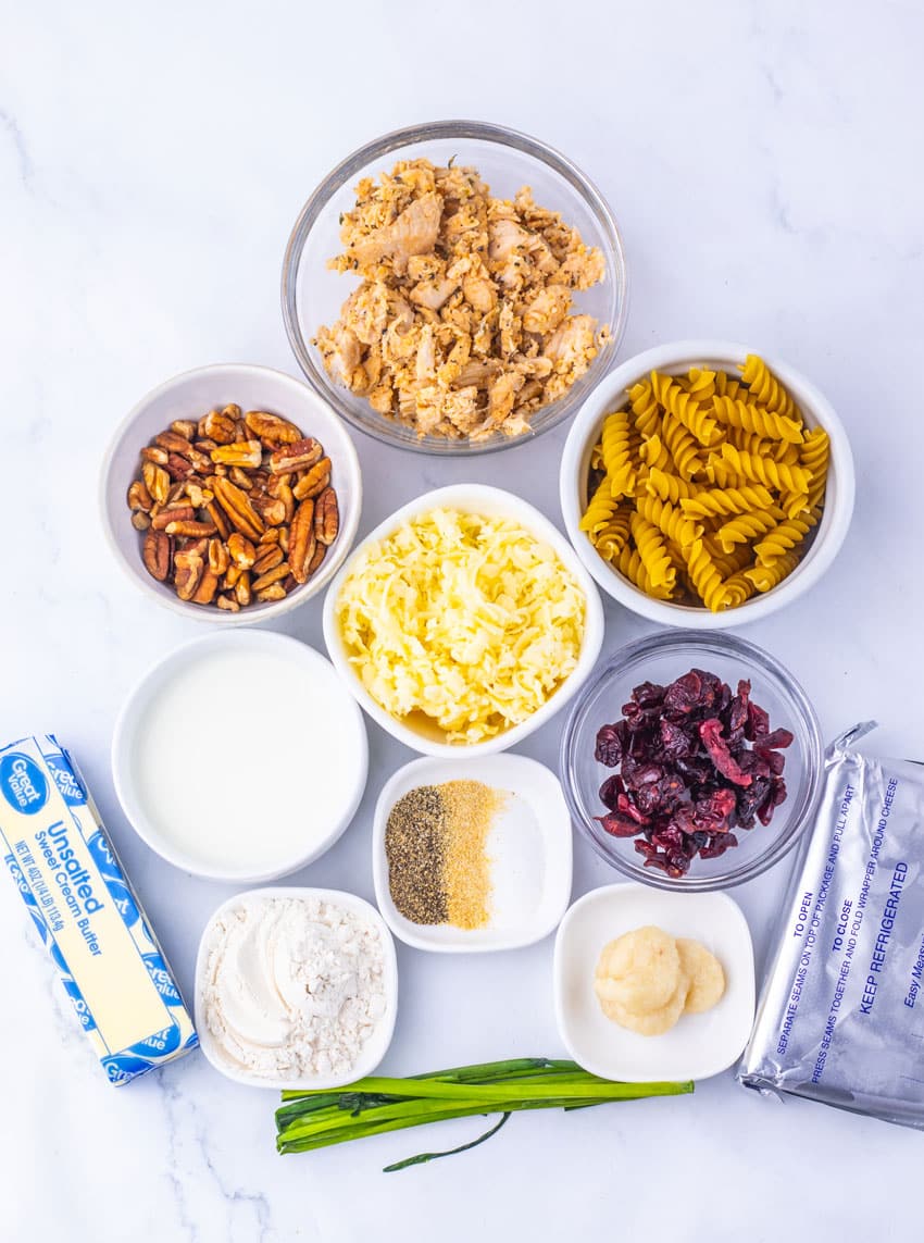 an overhead image showing the measured ingredients needed to make a batch of cranberry white cheddar chicken pasta