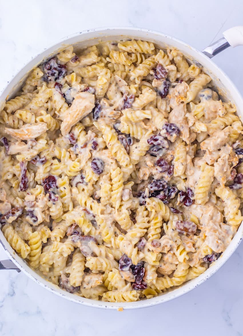 cranberry white cheddar chicken pasta in a large white skillet