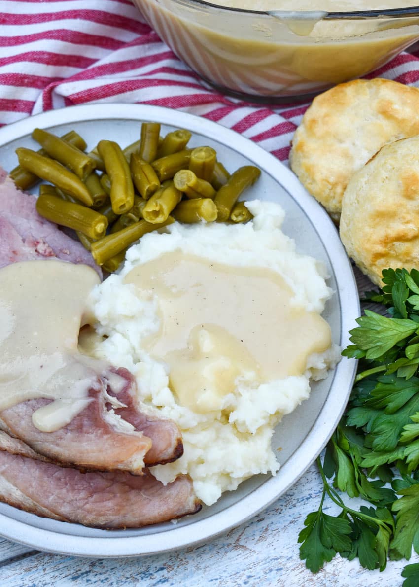 easy ham gravy over creamy mashed potatoes on a white dinner plate