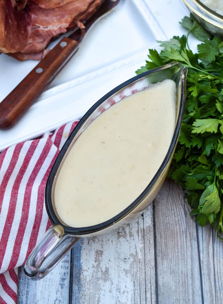 homemade gravy made from ham drippings in a glass gravy boat