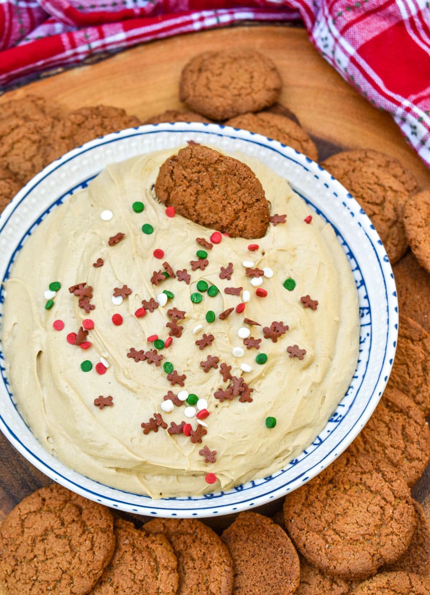 gingerbread cheesecake dip in a white bowl surrounded by gingersnap cookies