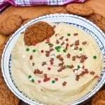 gingerbread cheesecake dip in a white bowl surrounded by gingersnap cookies