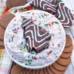 Chocolate Little Debbie Christmas Tree Cake dip in a white bowl topped with festive sprinkles and a dessert cake in the center