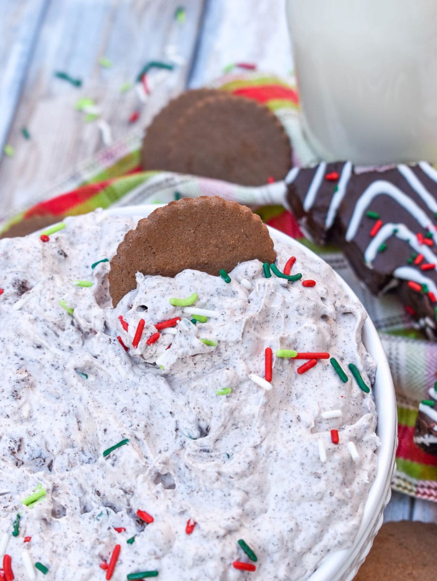 a hot cocoa cookie in a bowl of christmas tree cake dip