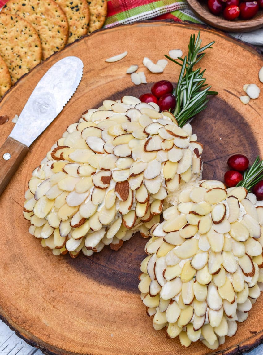 pinecone holiday cheese balls on a wooden serving board