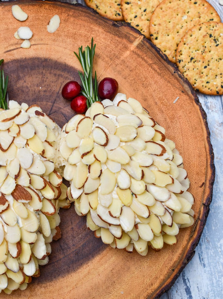 pinecone holiday cheese balls on a wooden serving board