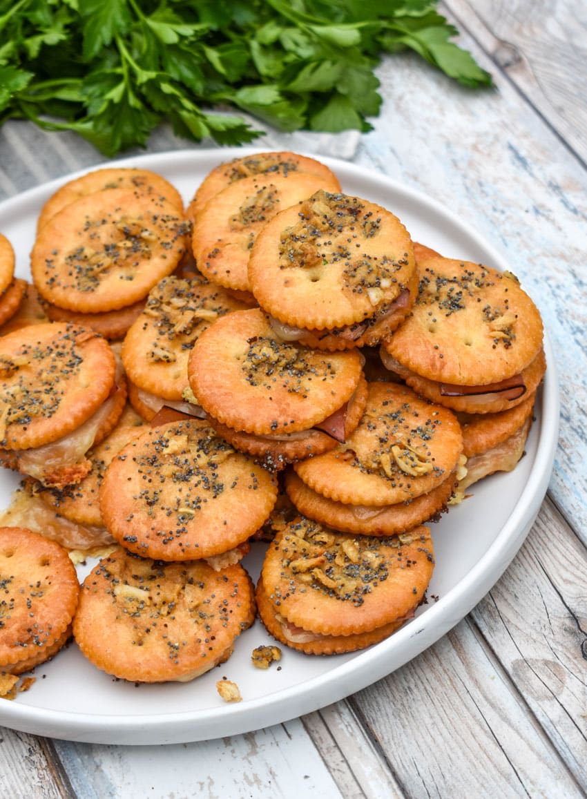 ritz cracker party sandwiches stacked on a white plate