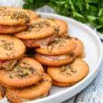 ritz cracker party sandwiches stacked on a white plate