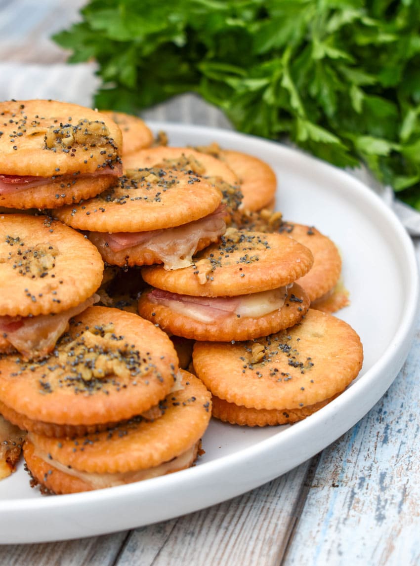 ritz cracker party sandwiches stacked on a white plate