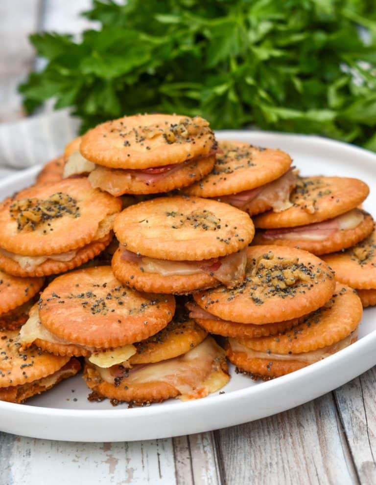 ritz cracker party sandwiches stacked on a white plate