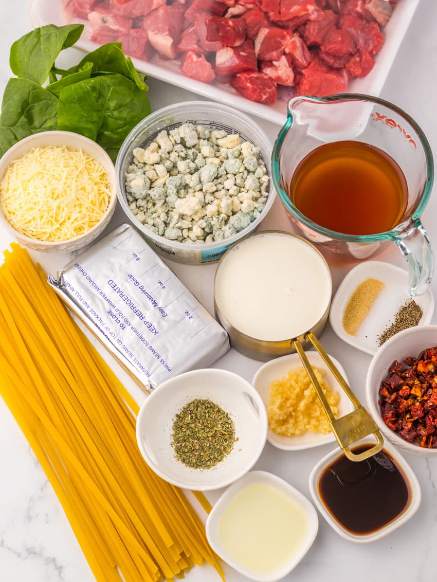 an overhead image showing the measured ingredients needed to make a copycat olive garden steak gorgonzola pasta