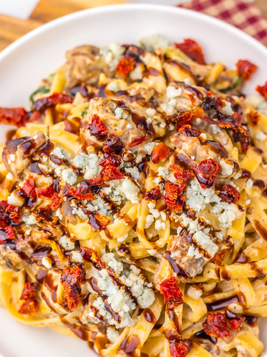 a close up of homemade steak gorgonzola pasta in a shallow white bowl