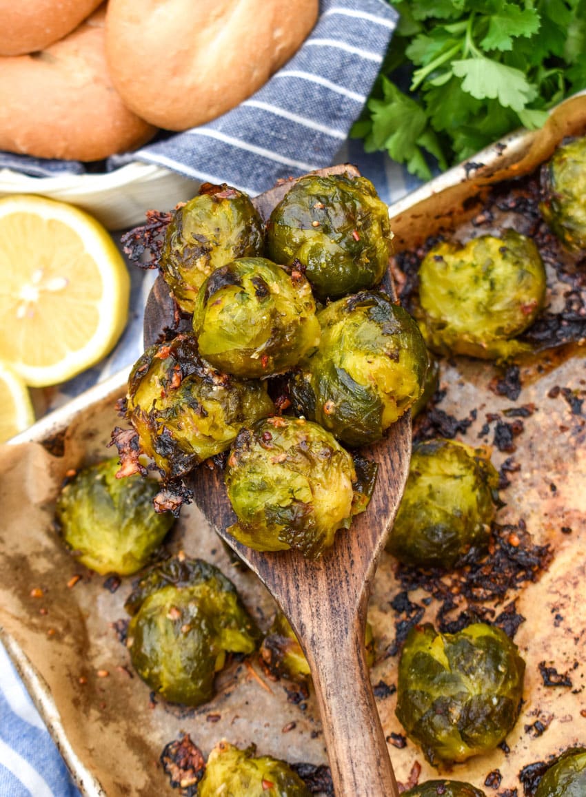 a wooden spatula holding up a scoop of smashed brussels sprouts