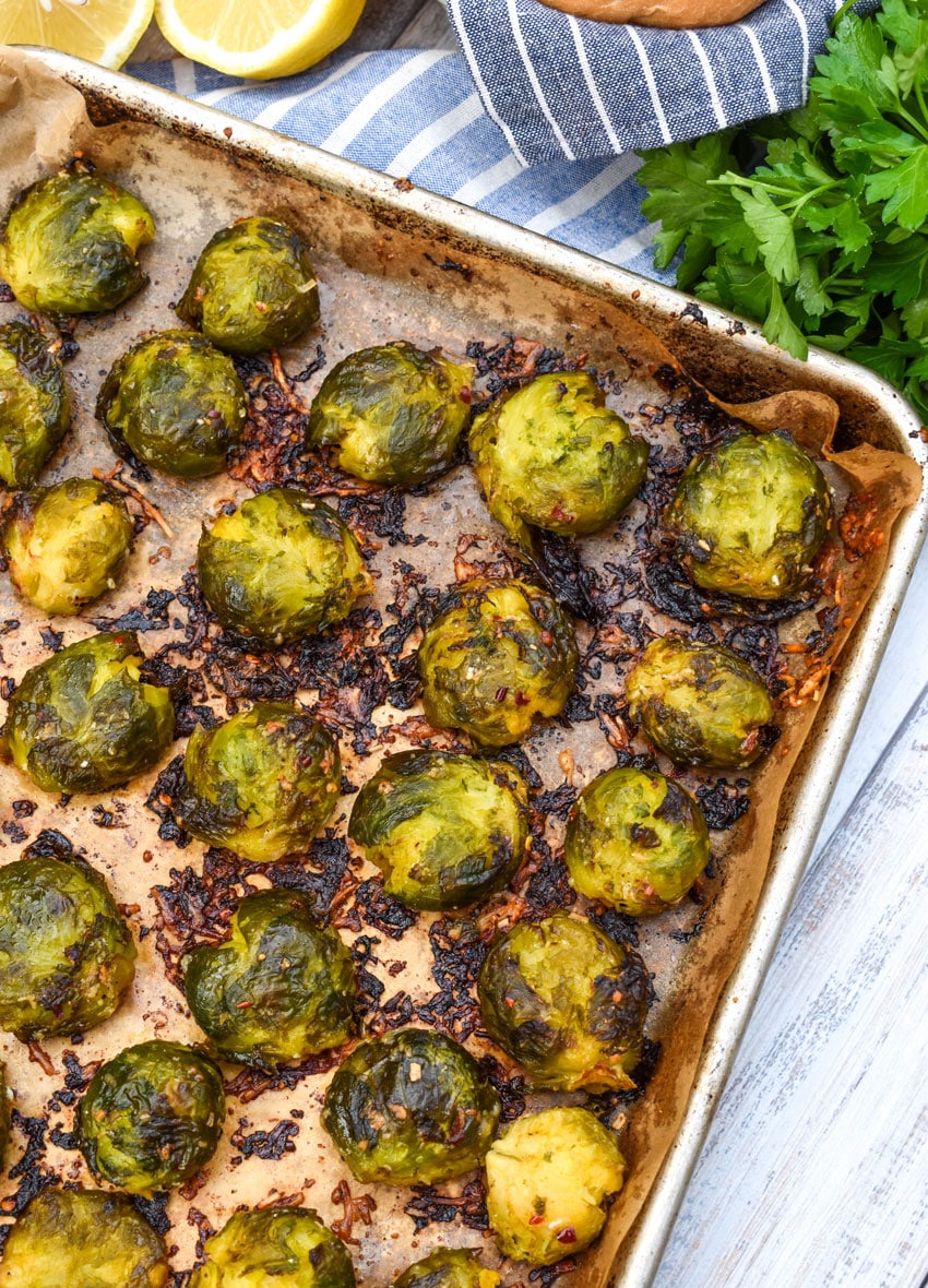 smashed brussels sprouts on a parchment paper lined baking sheet