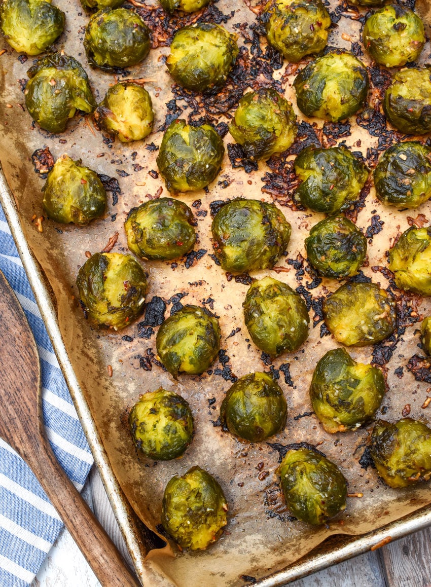 smashed brussels sprouts on a parchment paper lined baking sheet