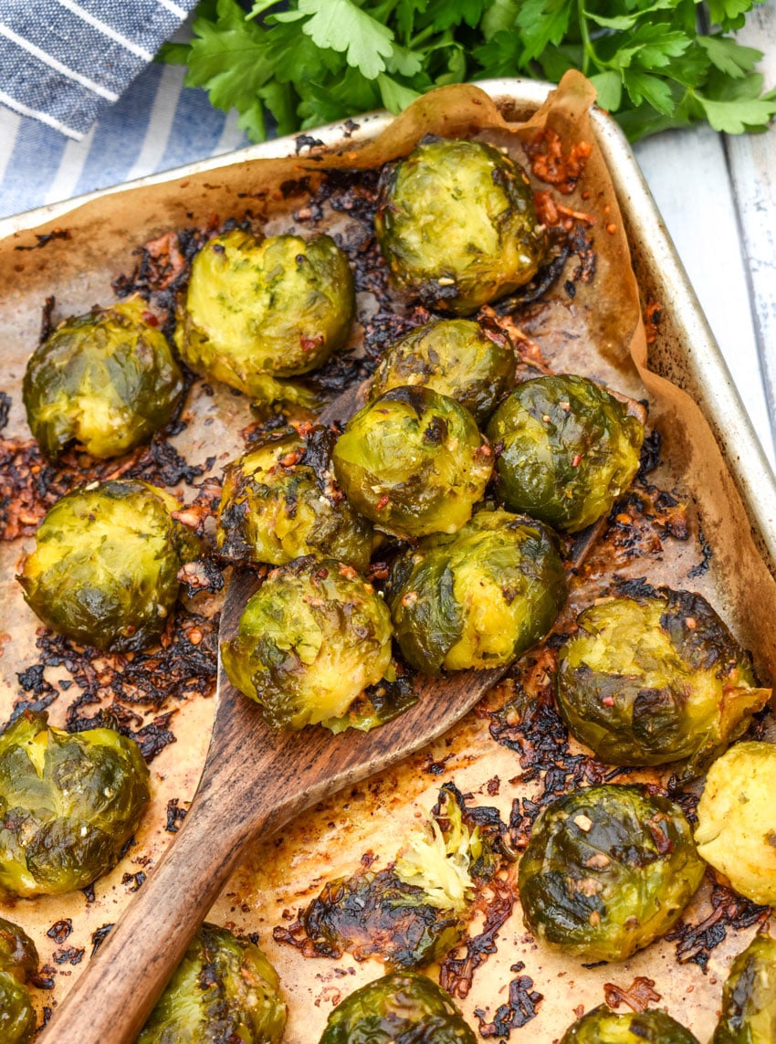 smashed brussels sprouts on a parchment paper lined baking sheet