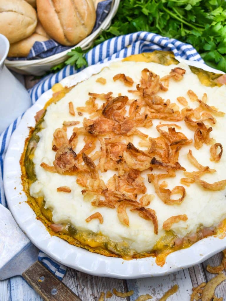 a thanksgiving leftover pot pie on a wooden table with fresh herbs in the background